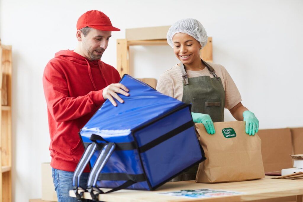 Fornecedora de alimentos entregando pacote para o delivery. 