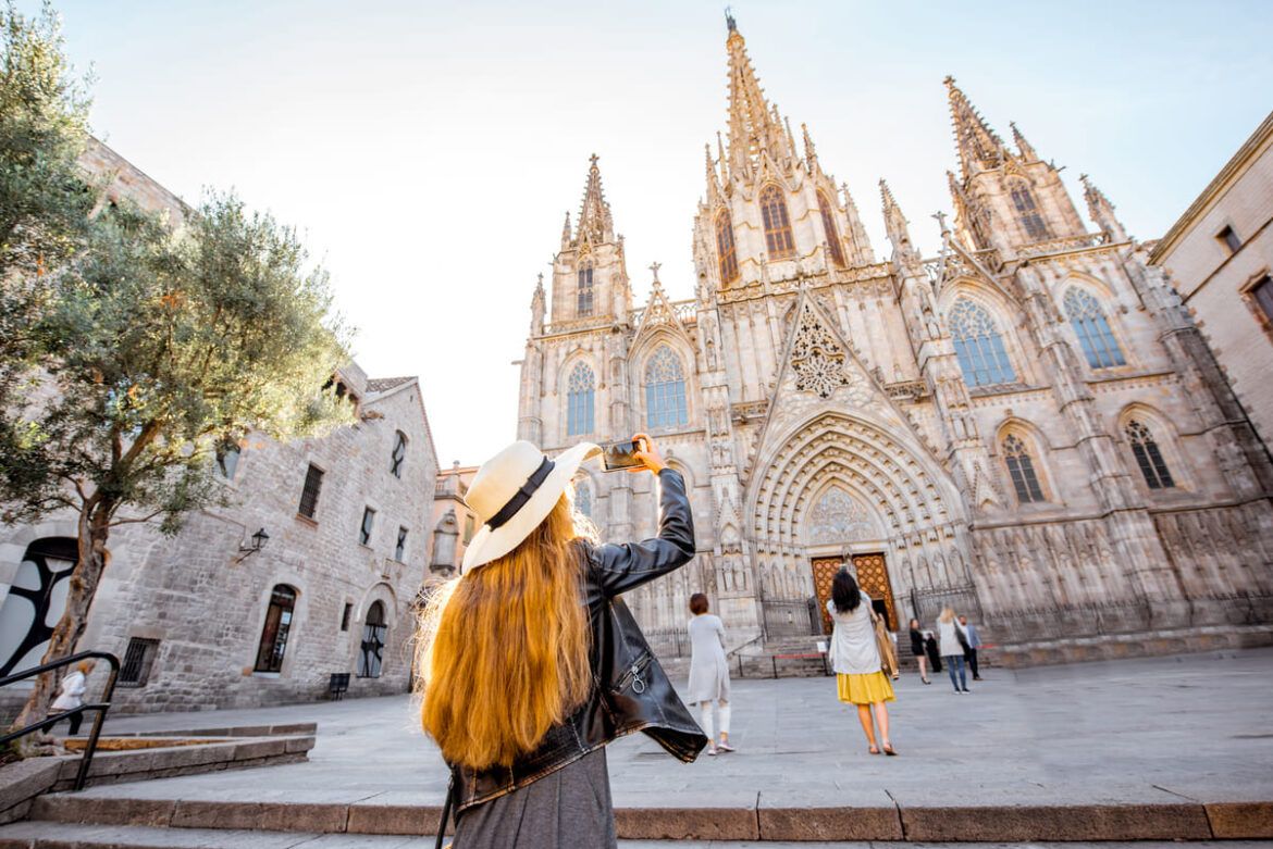 Mulher celebrando o Dia Mundial do Turismo em frente à Catedral de Barcelona, Espanha.