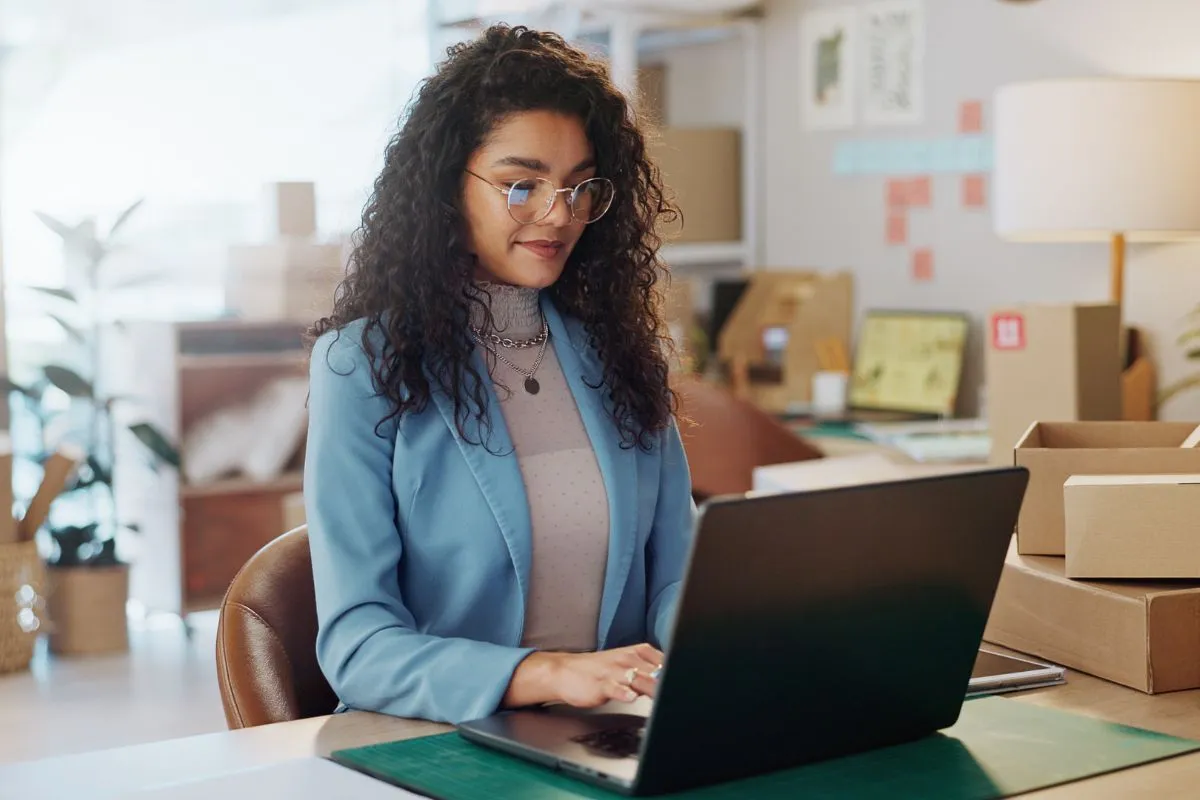 Empreendedora acessando o site do Appmax no seu escritório.