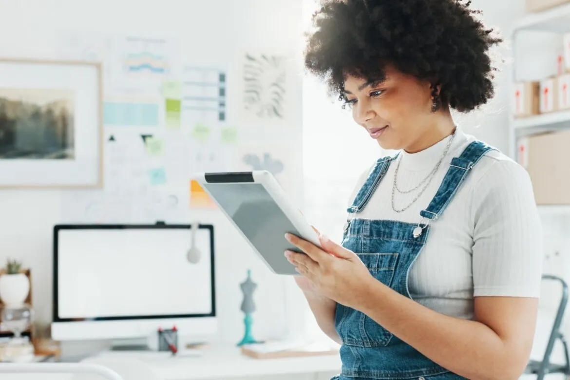 Mulher lendo sobre como fazer dropshipping no tablet.