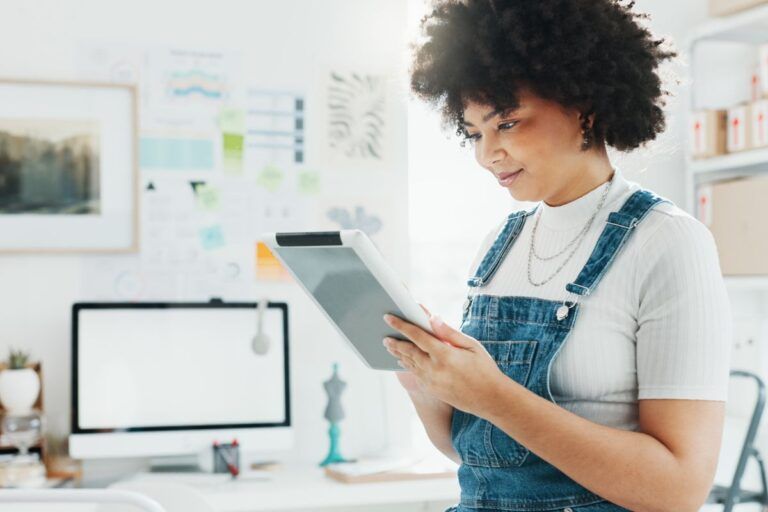 Mulher lendo sobre como fazer dropshipping no tablet.