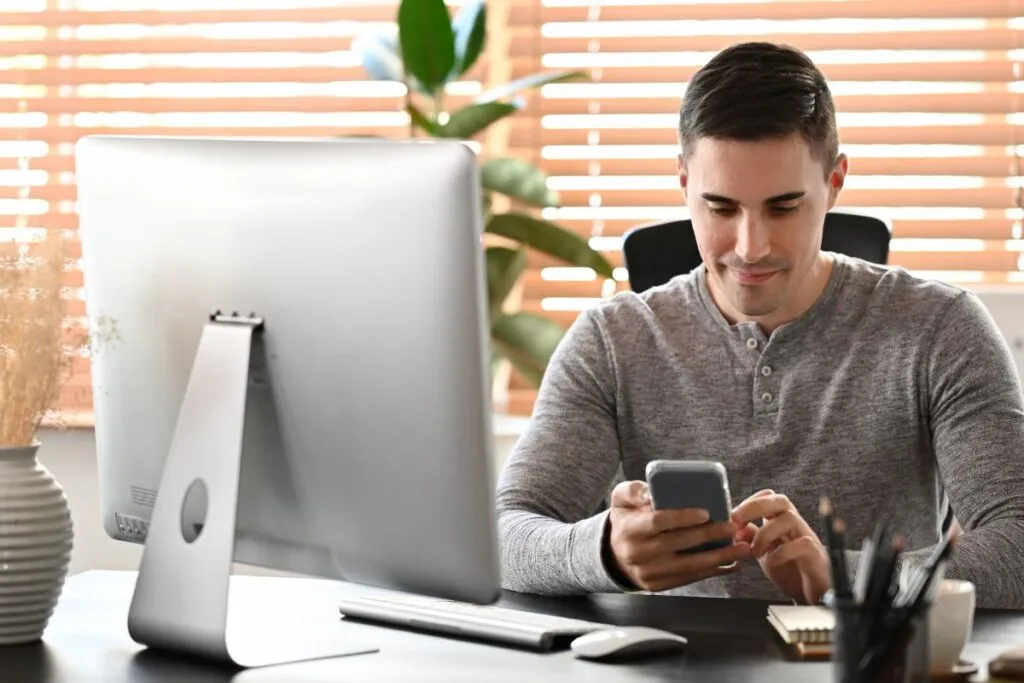 Homem no escritório acessando o smartphone 