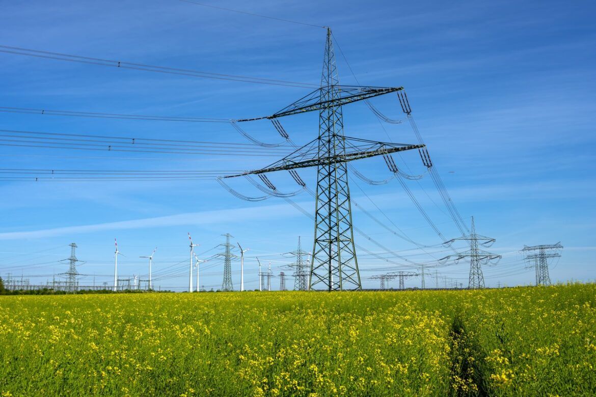 Imagem de postes de eletricidade e fios representando o mercado livre de energia.