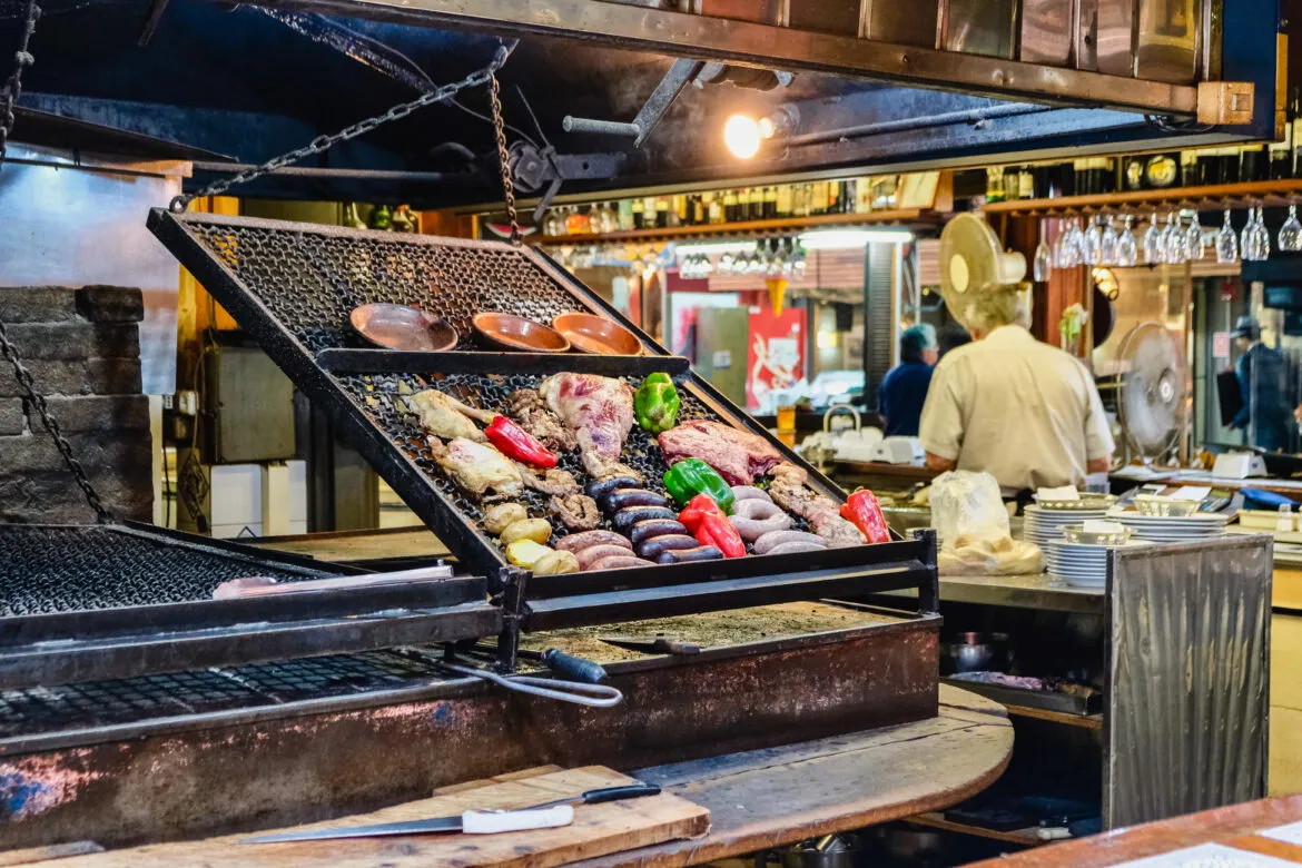 Imagem do Mercado do Porto em Motevidéu com parrilas expostas.