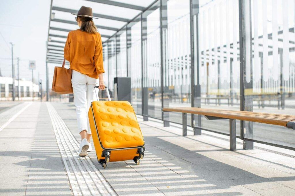 Mulher com bagagem de mão para viajar barato