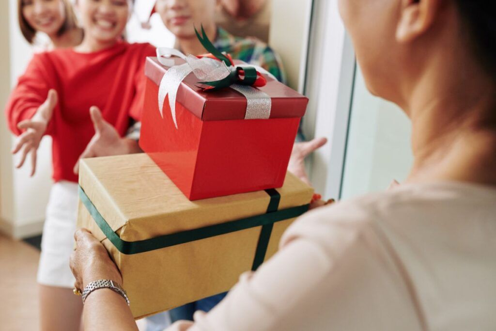 Mulher entregando presentes para Papai Noel dos Correios.