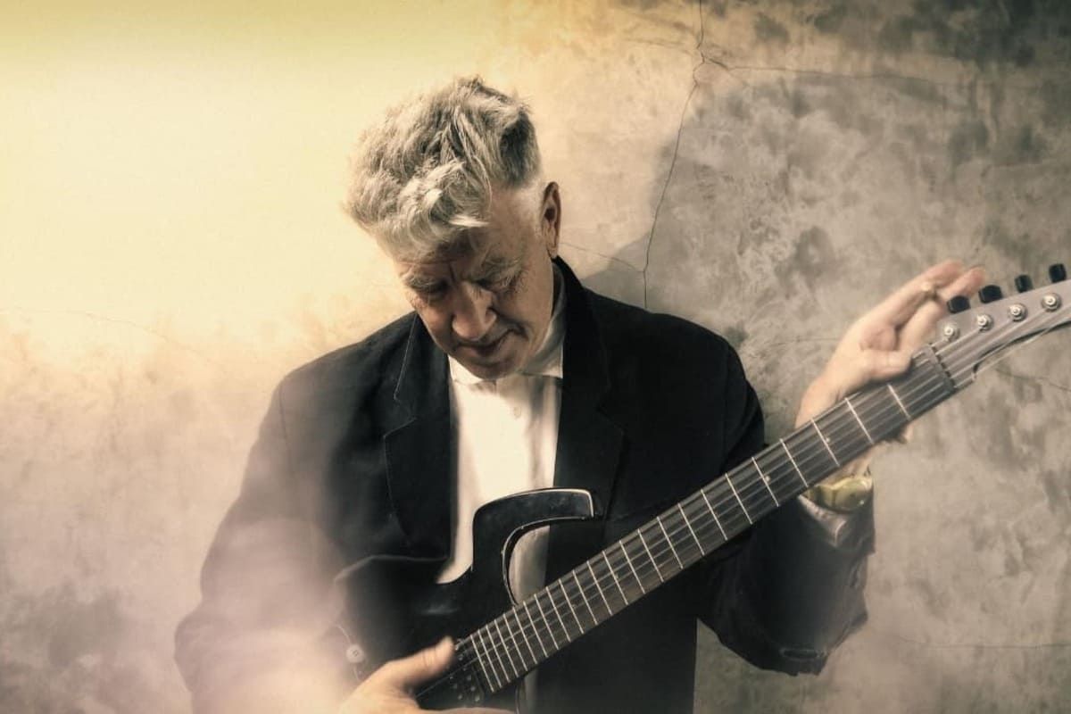 David Lynch morre. Artista aparece na foto tocando guittara.