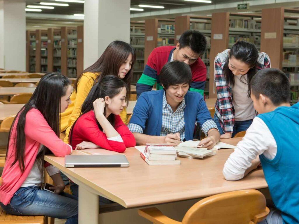 Grupo de alunos estudando na biblioteca